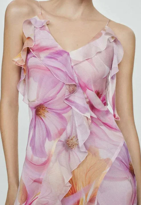 Floral pink - Model wearing a flowing chiffon maxi dress featuring a large-scale watercolor floral print, delicate spaghetti straps, cascading ruffles, and a high side slit.