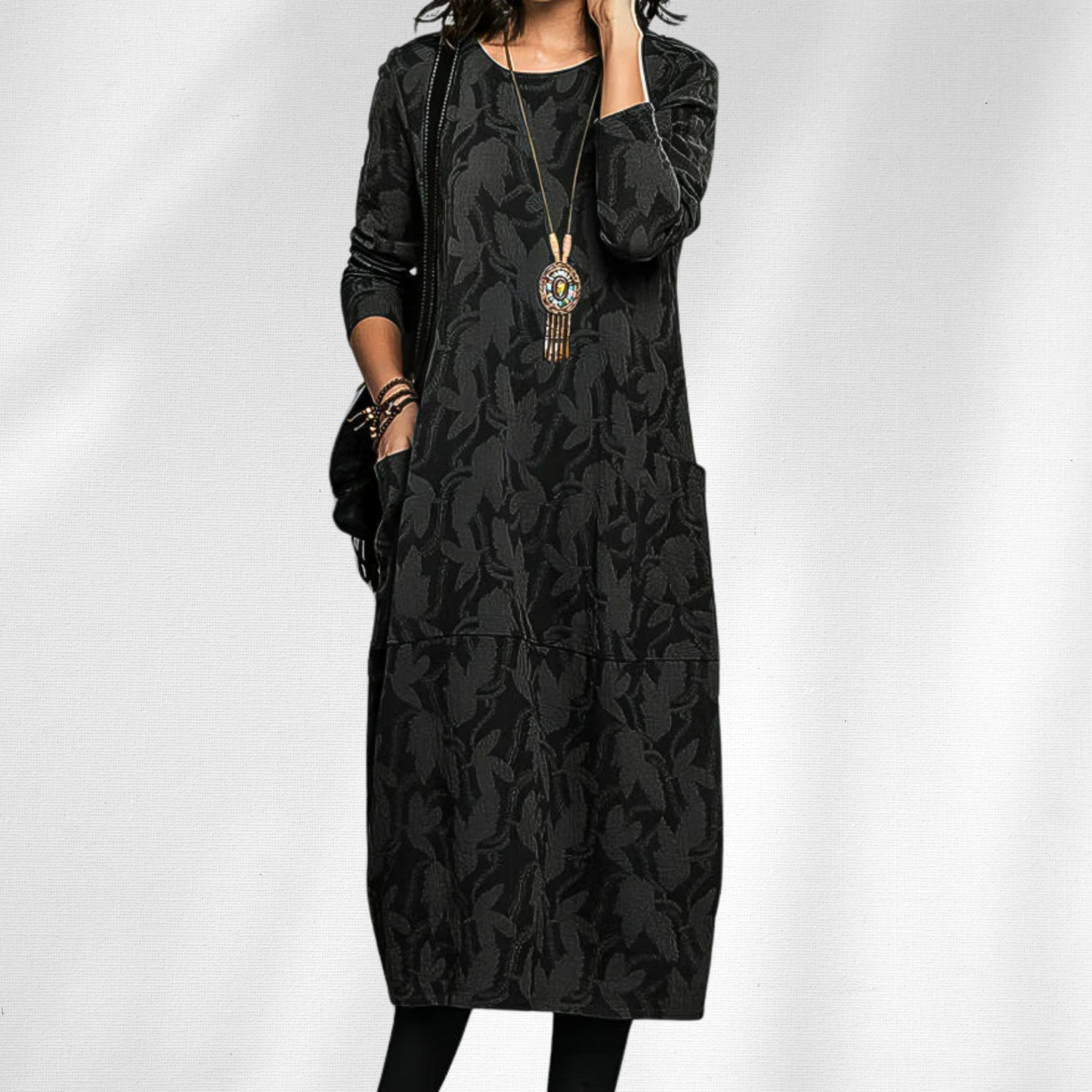 Black - Woman wearing a relaxed fit long sleeve midi dress with a tonal floral pattern and front patch pockets