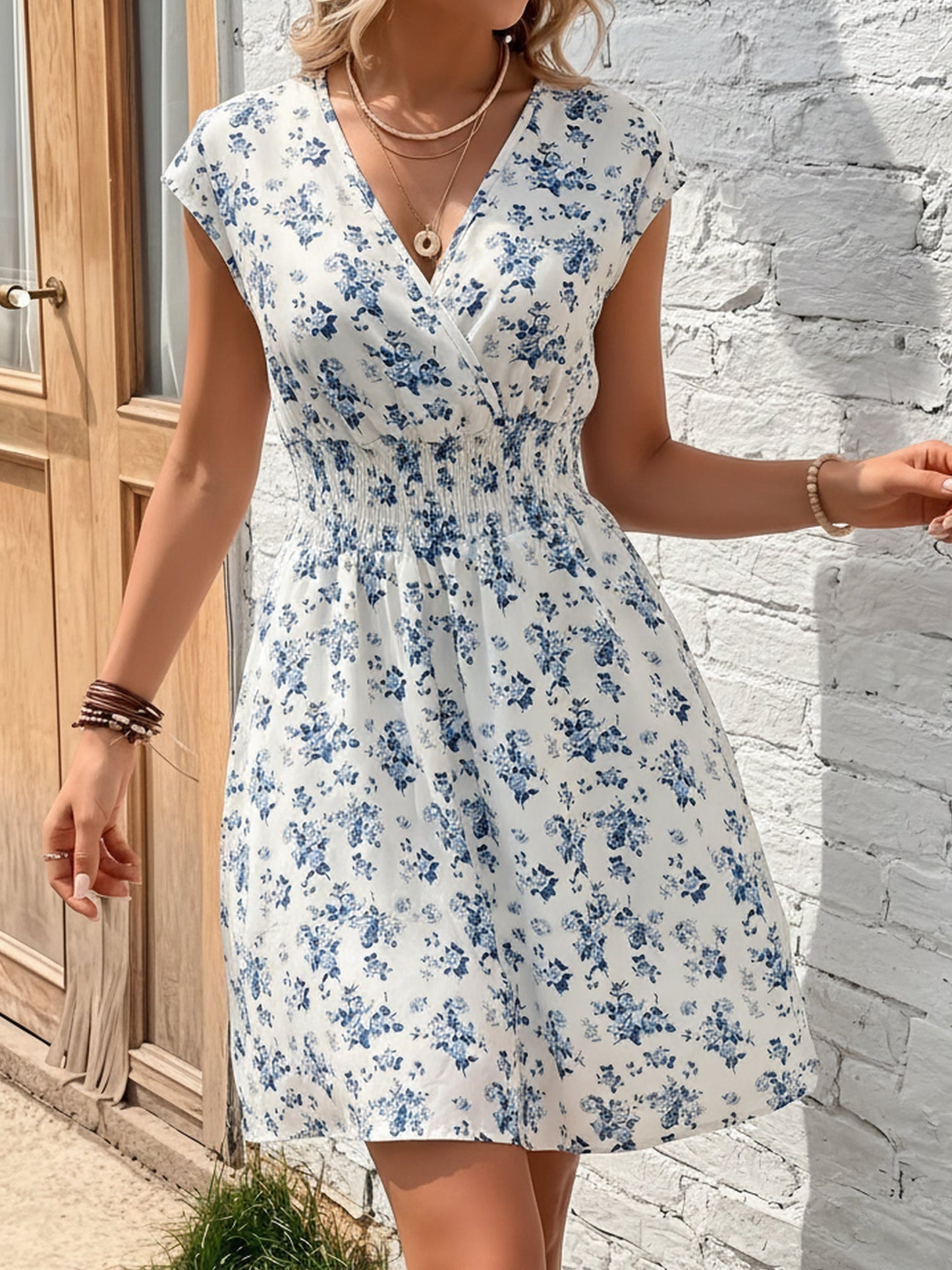 Blue - Woman wearing a lightweight chiffon mini dress with a leopard print, cap sleeves, and a smocked waist