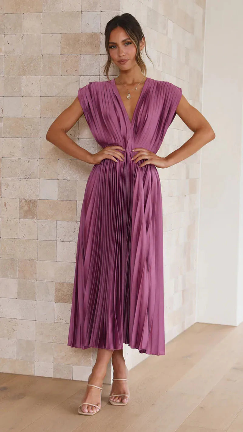Purple - Champagne pleated midi dress featuring a plunging V-neckline, wide banded waist, and a fluid A-line skirt.