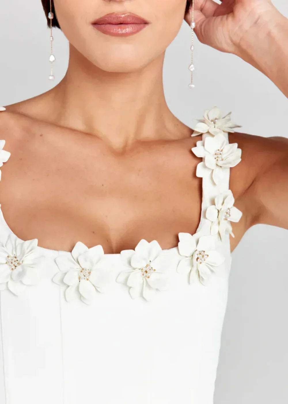 Black - Black structured crepe mini dress featuring a tailored bodice, A-line skirt with side pockets, and contrasting white 3D floral appliqués along the square neckline and shoulder straps.