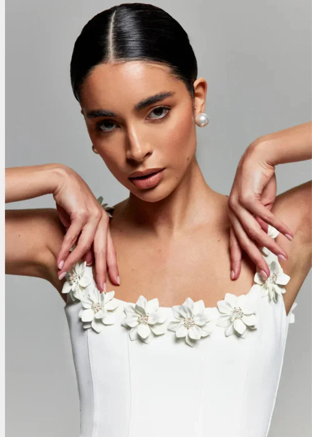 Black - Black structured crepe mini dress featuring a tailored bodice, A-line skirt with side pockets, and contrasting white 3D floral appliqués along the square neckline and shoulder straps.