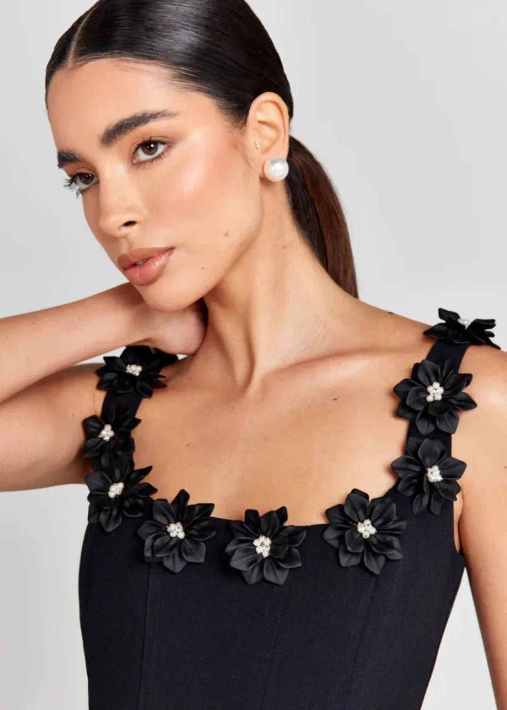 Black - Black structured crepe mini dress featuring a tailored bodice, A-line skirt with side pockets, and contrasting white 3D floral appliqués along the square neckline and shoulder straps.