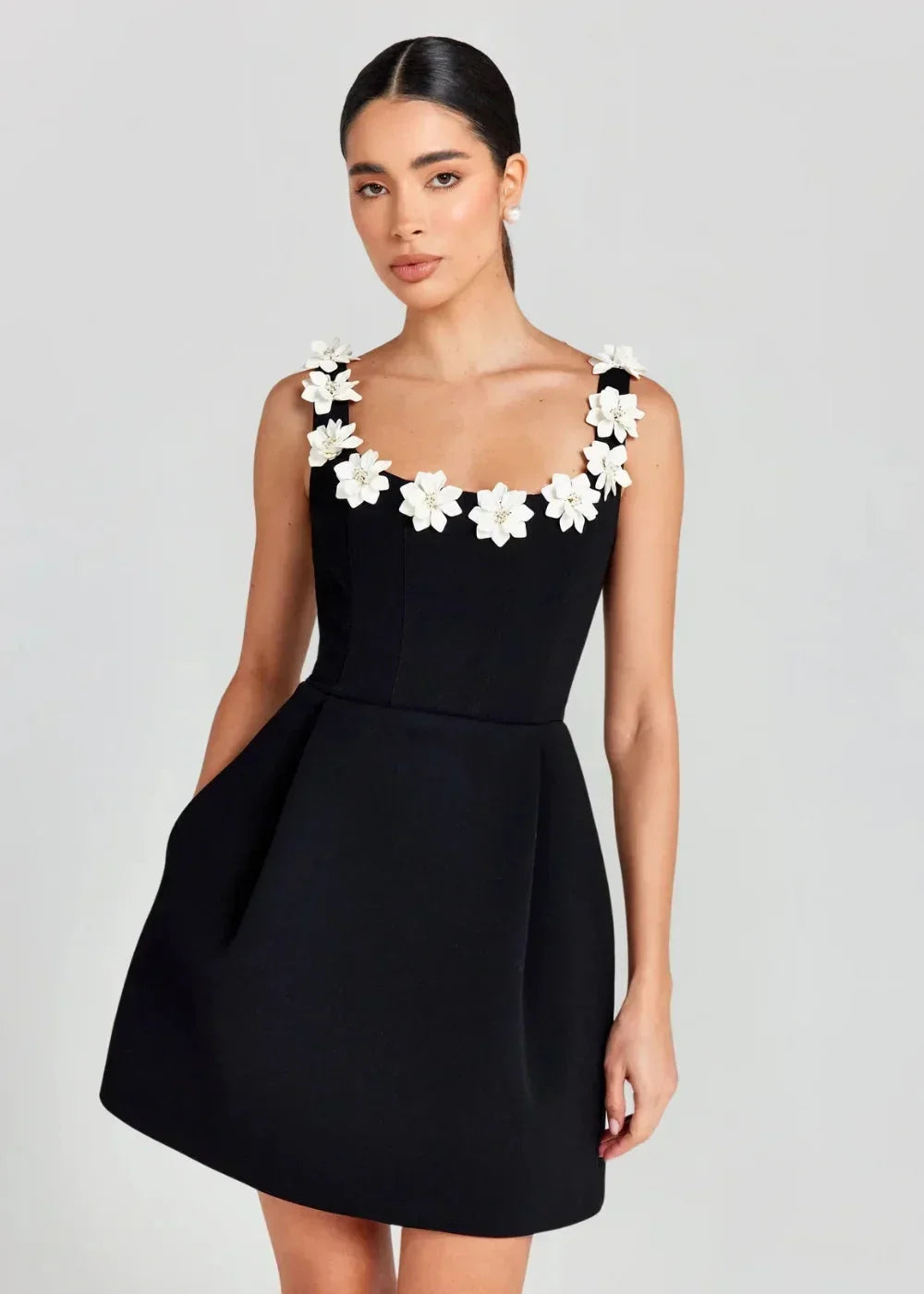 Black - Black structured crepe mini dress featuring a tailored bodice, A-line skirt with side pockets, and contrasting white 3D floral appliqués along the square neckline and shoulder straps.
