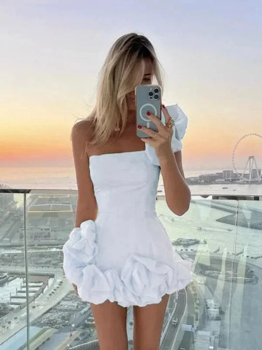 White - White one-shoulder mini dress featuring a fitted bodice and oversized 3D rosette details on the shoulder and hem.