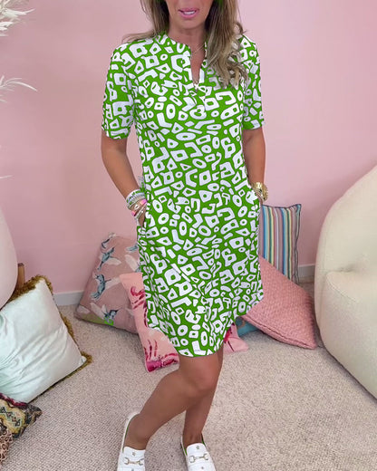 Green - A woman wearing a black and white abstract geometric print shift dress with short sleeves, a split neckline, and side pockets.