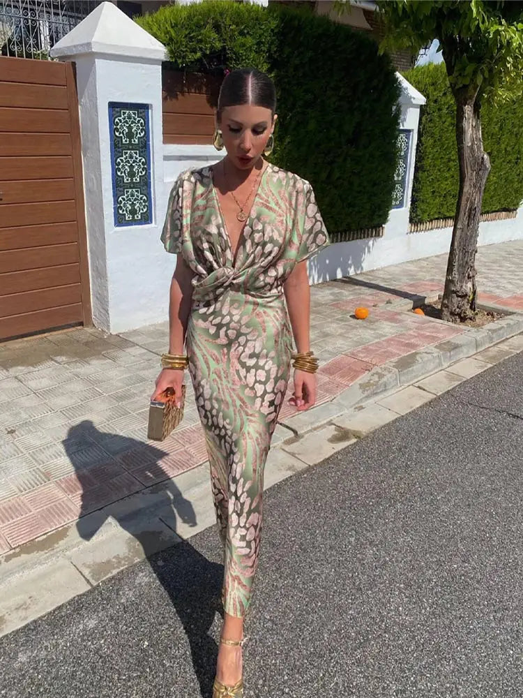Green - Woman wearing an abstract green and pink animal print satin midi dress with a plunging neckline and twist-front waist detail.