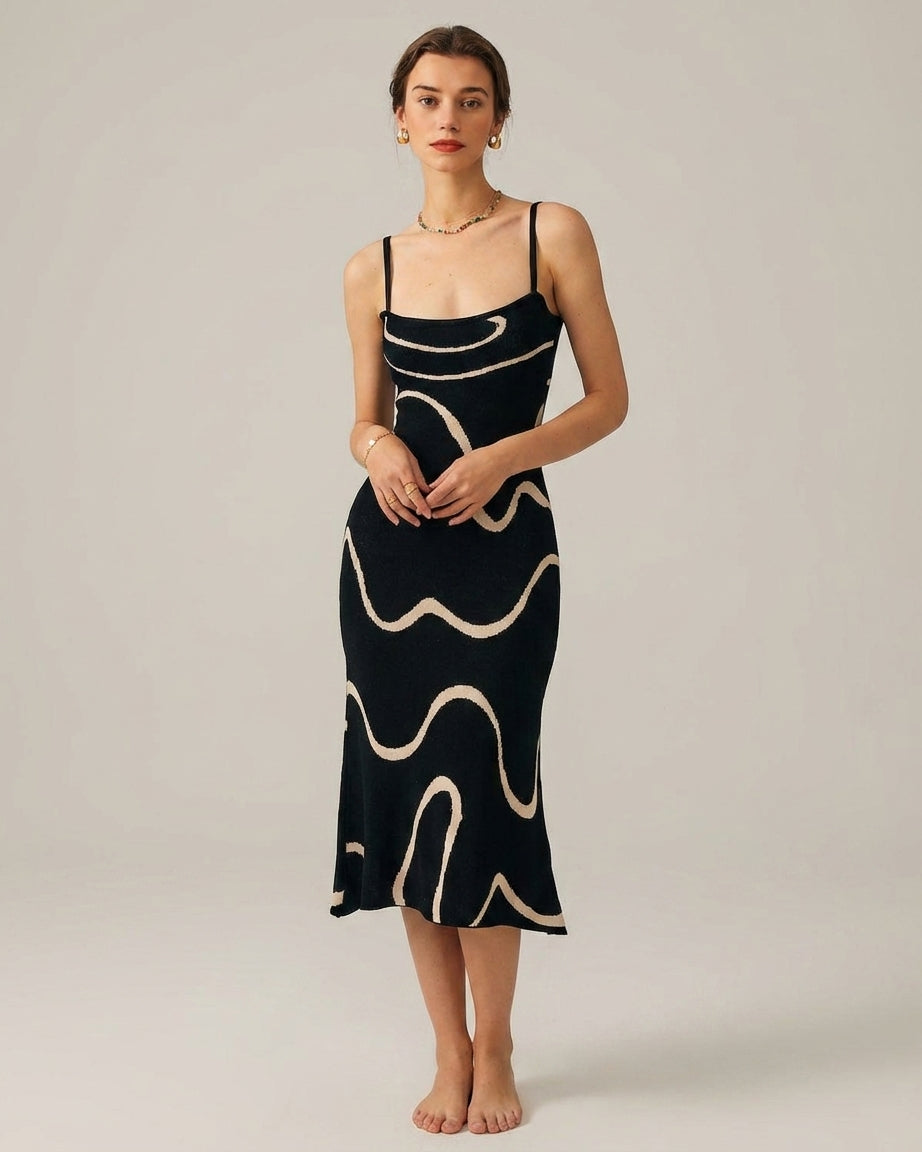 Black - A woman wearing a black knit midi dress featuring a cream abstract wave pattern, thin spaghetti straps, and a square neckline.