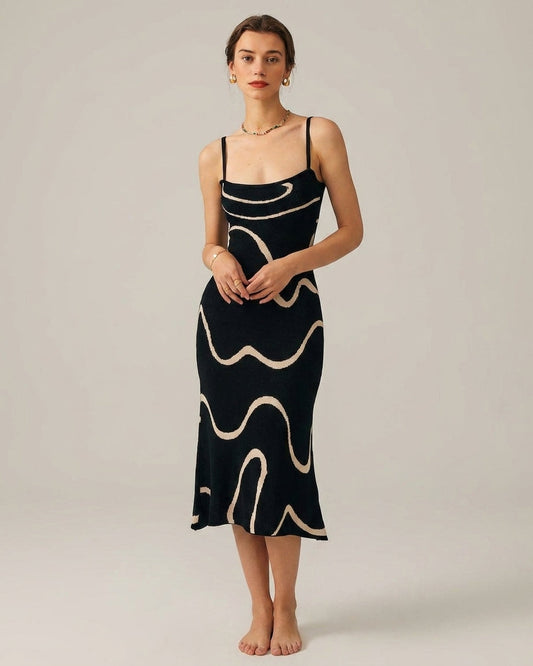 Black - A woman wearing a black knit midi dress featuring a cream abstract wave pattern, thin spaghetti straps, and a square neckline.