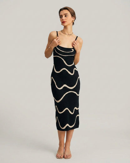 Black - A woman wearing a black knit midi dress featuring a cream abstract wave pattern, thin spaghetti straps, and a square neckline.