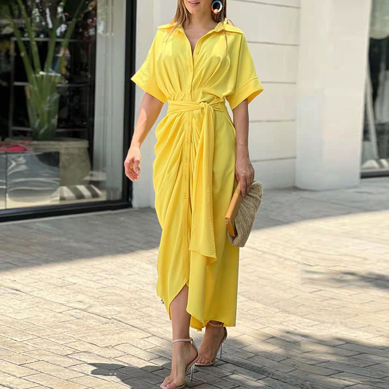 Yellow - A woman wearing a green and cream botanical print midi shirt dress with a button-down front, belted waist, and draped skirt detail.