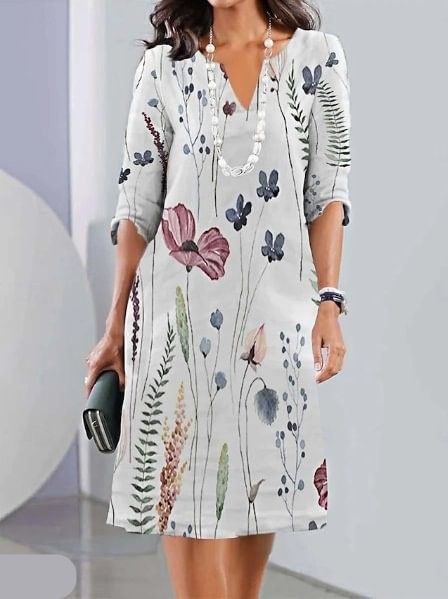 Off-white - A woman wearing a slate blue knee-length shift dress with a dark blue botanical floral print, featuring a split neckline, three-quarter sleeves, and a relaxed straight fit.