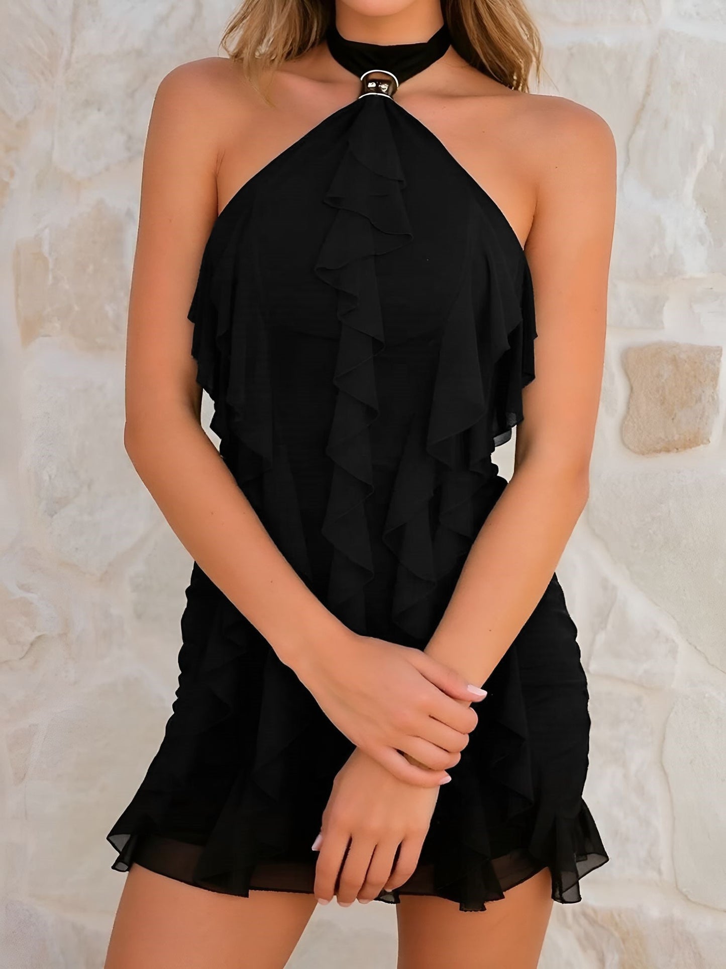 Black - Woman wearing a sheer chiffon mini dress featuring a halter neckline with hardware and cascading vertical ruffles.
