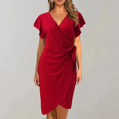Solid red crepe midi dress featuring a surplice V-neckline, short flutter sleeves, a ruched side tie waist, and an asymmetrical tulip hem.
