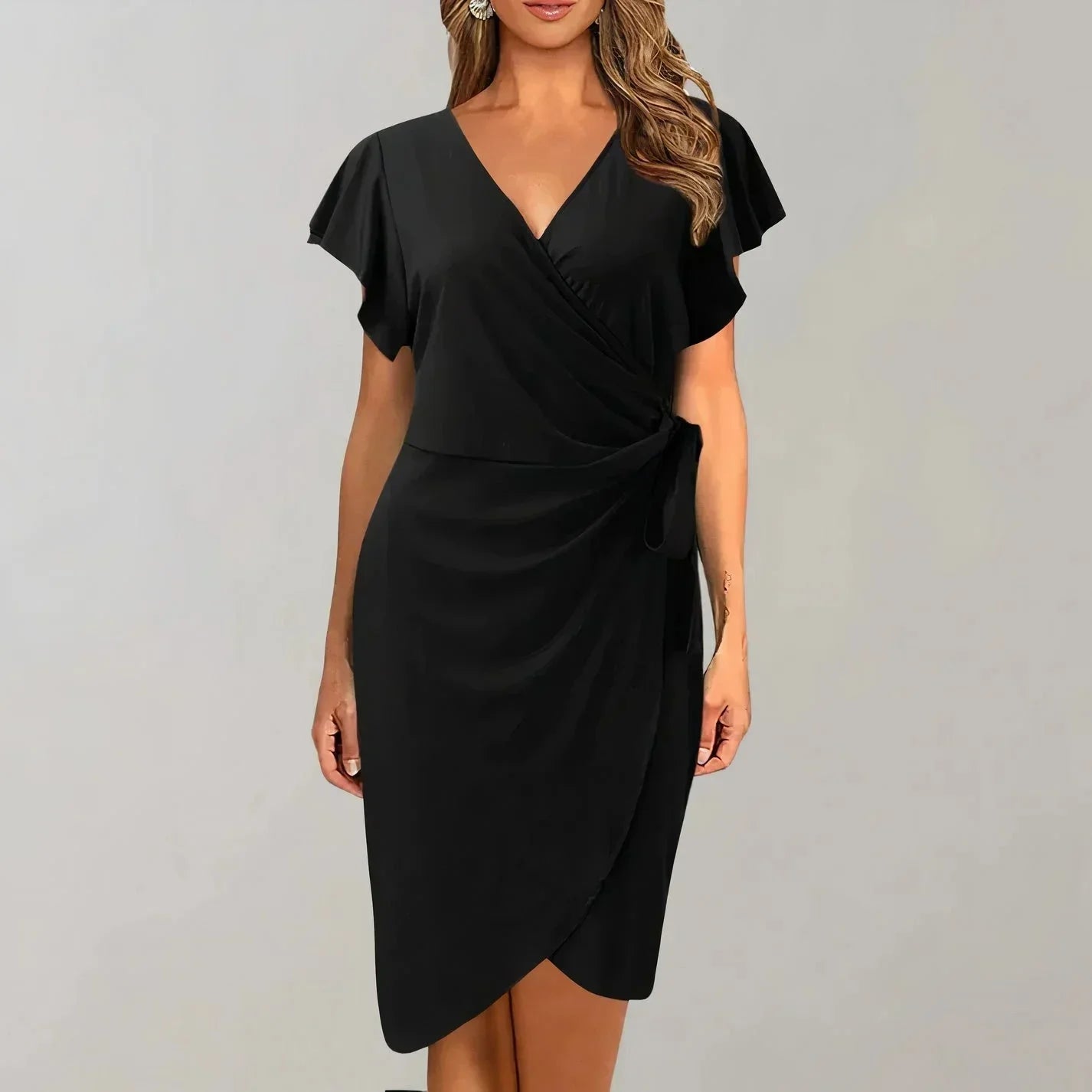 Black - Solid red crepe midi dress featuring a surplice V-neckline, short flutter sleeves, a ruched side tie waist, and an asymmetrical tulip hem.