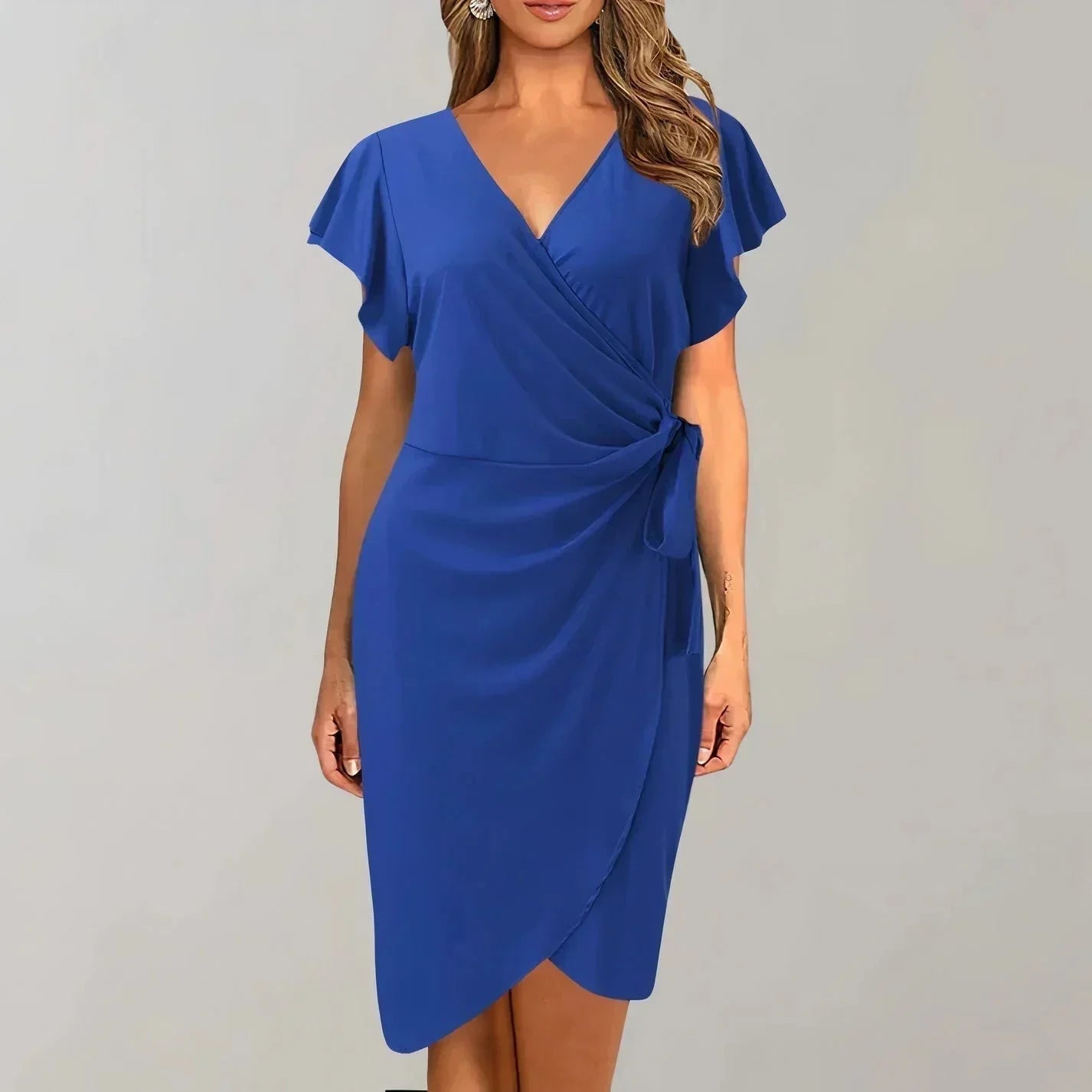 Blue - Solid red crepe midi dress featuring a surplice V-neckline, short flutter sleeves, a ruched side tie waist, and an asymmetrical tulip hem.