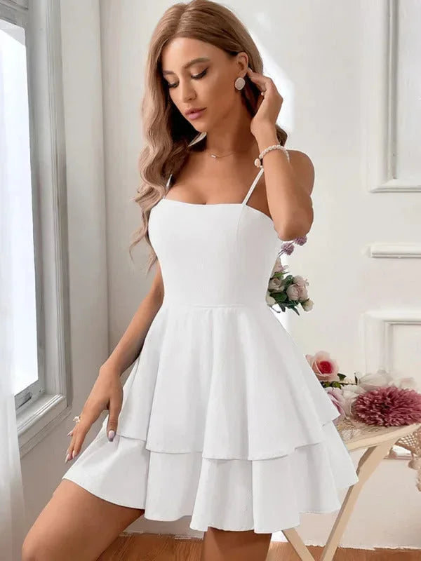 White - White crepe mini dress featuring a square neckline, thin spaghetti straps, a fitted bodice, and a two-tiered fit-and-flare skirt.