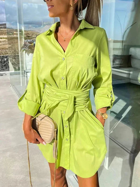 Bright green crisp button-front mini shirt dress with a point collar, rolled sleeves, and a defined tie-waist.