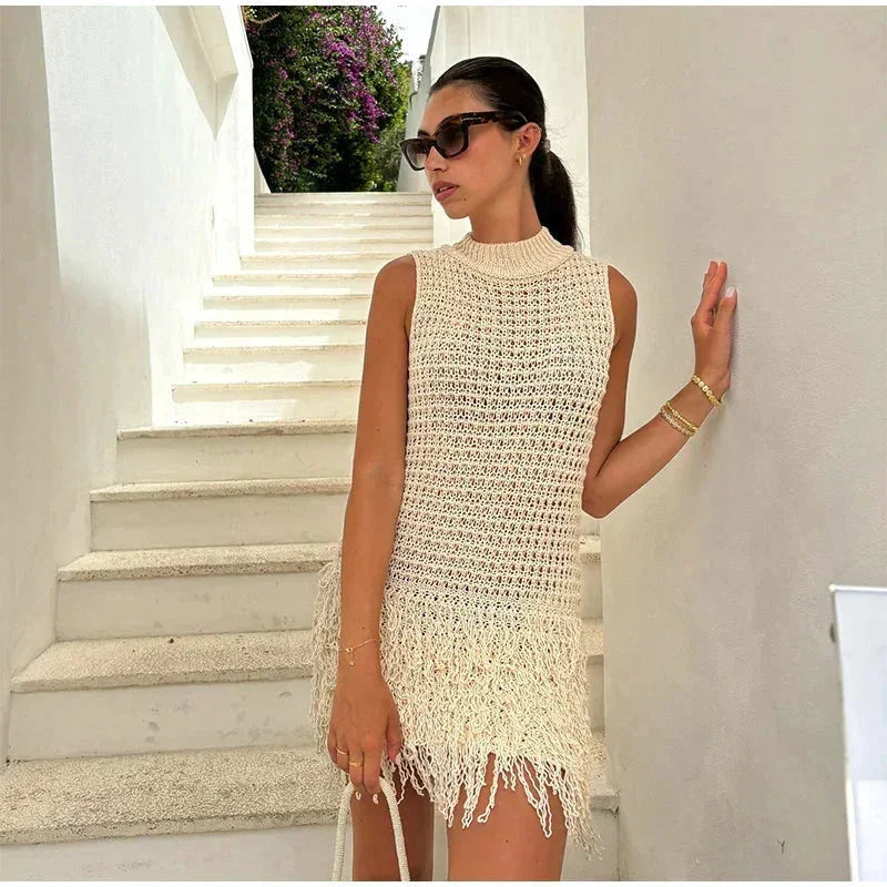 sand - Sleeveless crochet mini dress featuring a high mock neckline and a textured fringed hem.