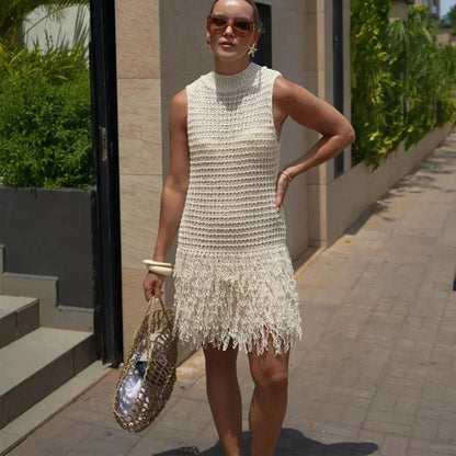 sand - Sleeveless crochet mini dress featuring a high mock neckline and a textured fringed hem.
