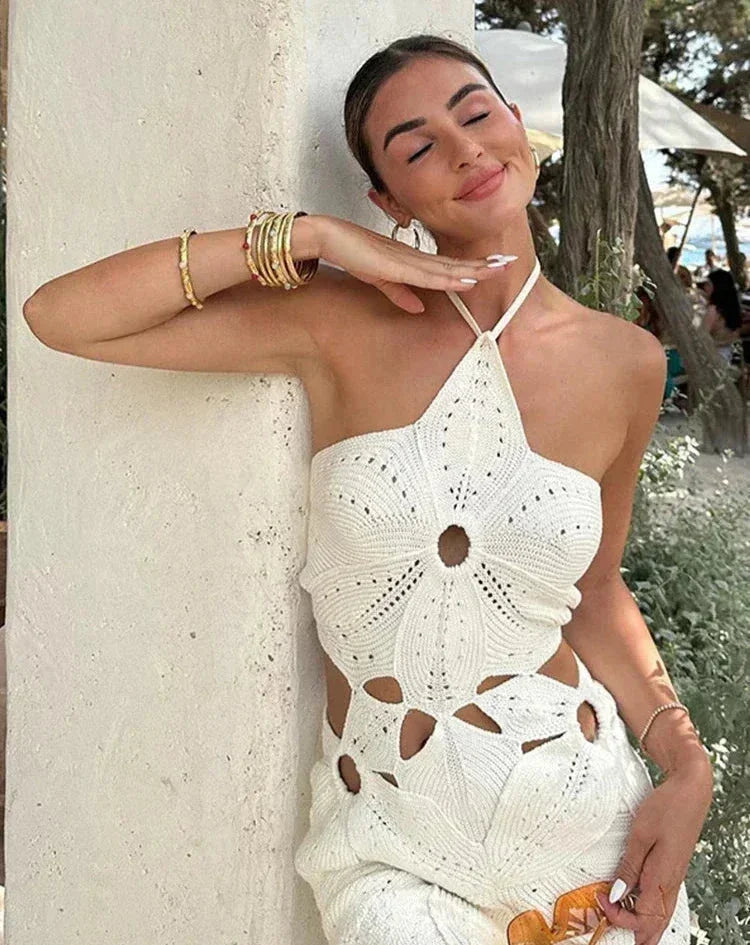 White - White crochet halter mini dress featuring large botanical cutouts, an asymmetrical hem, and an open waist design.