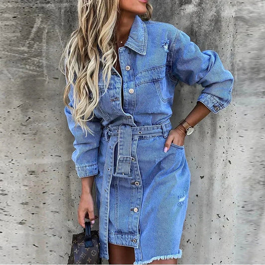 Blue - Light blue wash denim long-sleeve mini shirt dress featuring a button-front closure, matching grommet belt, distressed accents, and a raw frayed hem.