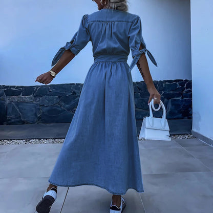Blue - Light blue denim A-line maxi dress featuring a plunging V-neckline, button-front closure, banded waist, and short sleeves with tie cuffs.