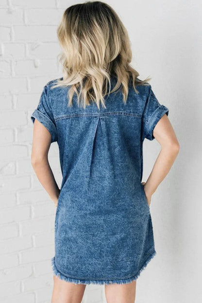 Blue - Woman wearing a relaxed fit mottled wash denim mini shirt dress with rolled short sleeves, a button-front closure, and a frayed raw hem.