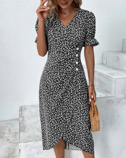 Red - A woman wearing a blue and white ditsy floral midi dress featuring a V-neckline, ruched side detailing with white buttons, and short puff sleeves with ruffled cuffs.