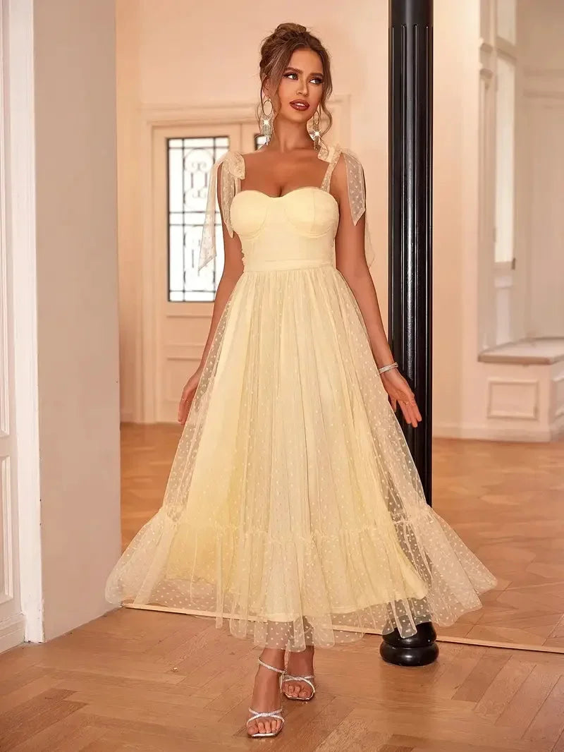 Yellow - Bright pink dotted tulle midi dress featuring a ruched bustier bodice, adjustable tie shoulder straps, and a voluminous gathered skirt.