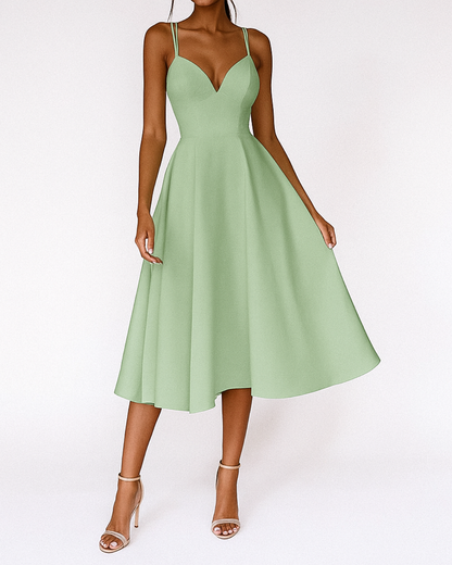Green - A woman wearing a structured white textured crepe midi dress with double spaghetti straps, a sweetheart neckline, and a flared A-line skirt.