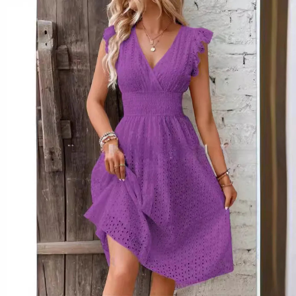 Purple - A woman wearing a white eyelet midi dress with flutter sleeves, a surplice V-neckline, and a wide smocked waistband, standing against a rustic wooden door.