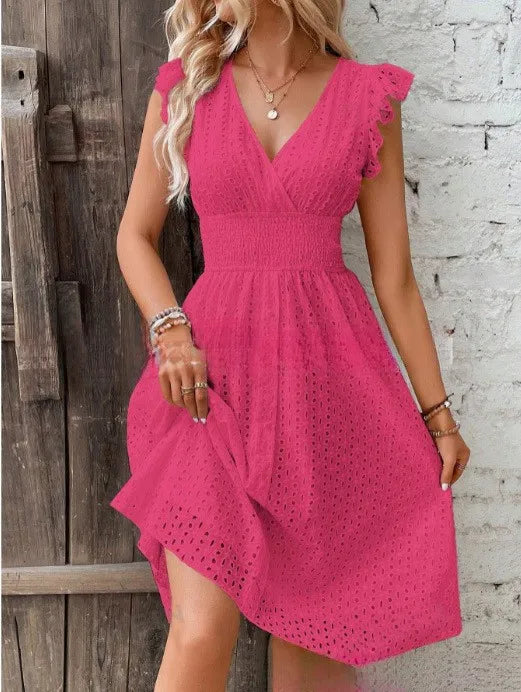 Rose red - A woman wearing a white eyelet midi dress with flutter sleeves, a surplice V-neckline, and a wide smocked waistband, standing against a rustic wooden door.