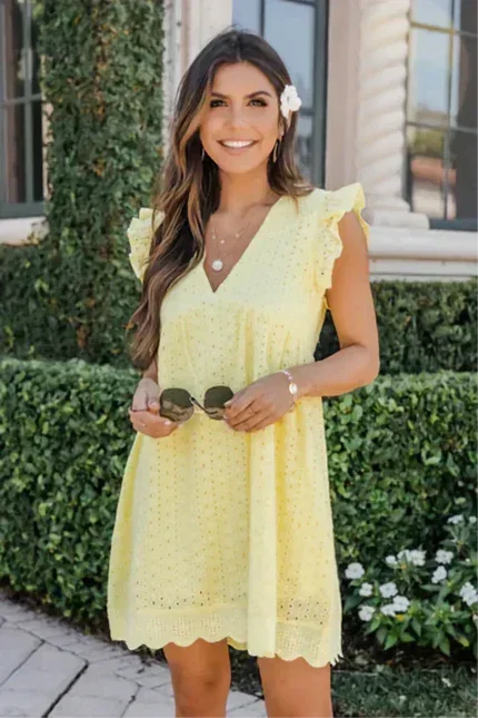 Yellow - White eyelet mini dress featuring a V-neckline, ruffle flutter sleeves, and a scalloped hem.