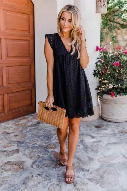 Black - White eyelet mini dress featuring a V-neckline, ruffle flutter sleeves, and a scalloped hem.