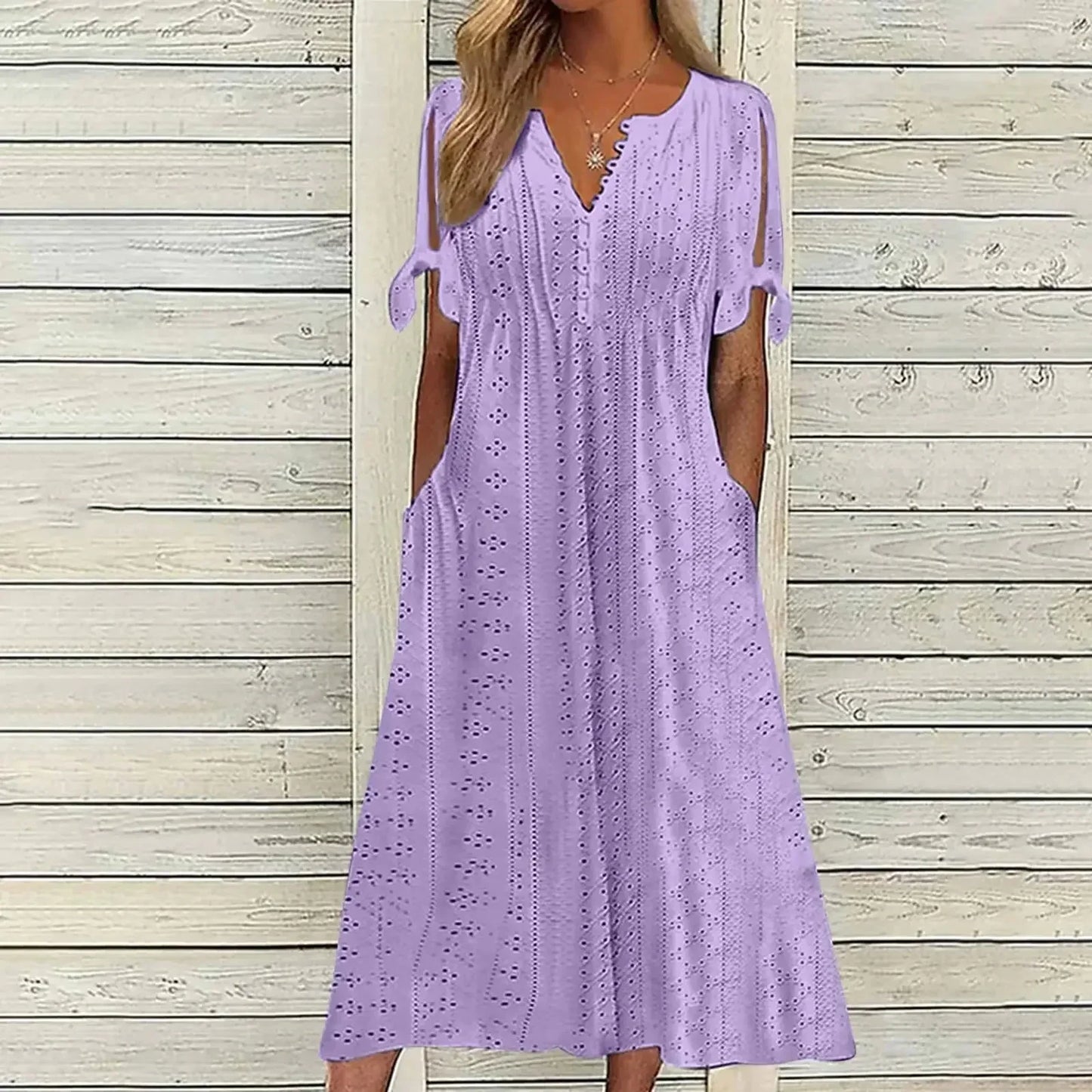PURPLE - A woman wearing a light blue midi-length eyelet dress with a scalloped V-neckline, split tie-sleeves, and side pockets, shown alongside color variations in pink, white, and mint green.