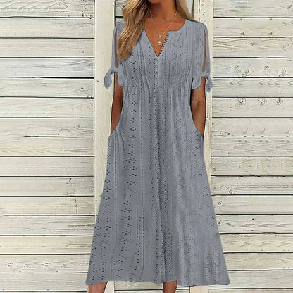GRAY - A woman wearing a light blue midi-length eyelet dress with a scalloped V-neckline, split tie-sleeves, and side pockets, shown alongside color variations in pink, white, and mint green.