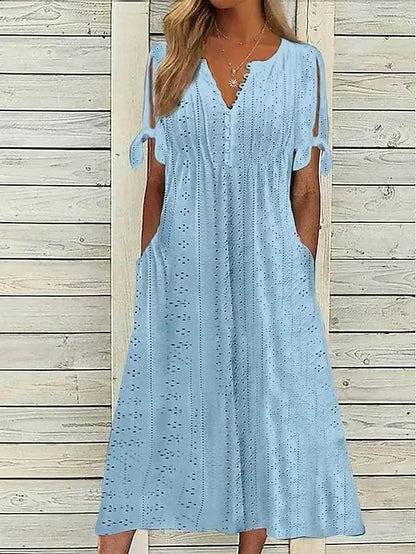 BLUE - A woman wearing a light blue midi-length eyelet dress with a scalloped V-neckline, split tie-sleeves, and side pockets, shown alongside color variations in pink, white, and mint green.