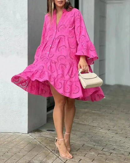 Bright pink eyelet mini dress featuring a collared button-front, voluminous bell sleeves, and a flowing tiered skirt.