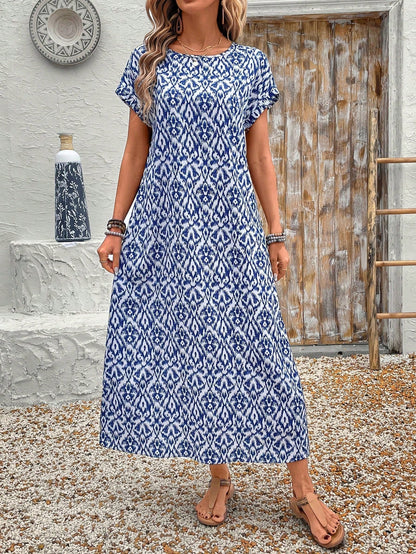 Dark Blue - A woman wearing a beige fine-knit maxi dress with cap sleeves and a crew neck, styled with gold jewelry and a woven clutch in a minimalist interior.