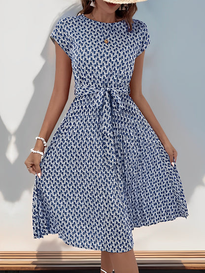 Navy Blue - Woman wearing a lightweight floral cap sleeve midi dress with a tie waist and pleated skirt.