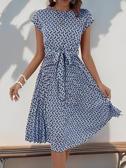 Navy Blue - Woman wearing a lightweight floral cap sleeve midi dress with a tie waist and pleated skirt.