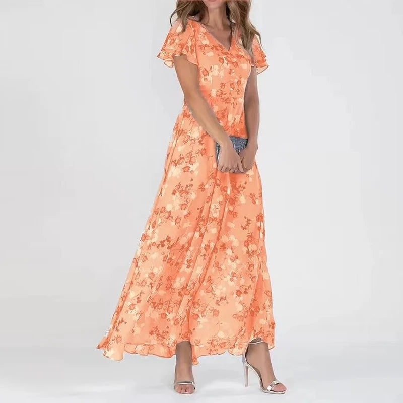 Orange - A woman wearing a dusty blue floral print chiffon maxi dress with flutter sleeves, a V-neckline, and a flowing skirt, paired with silver heeled sandals.