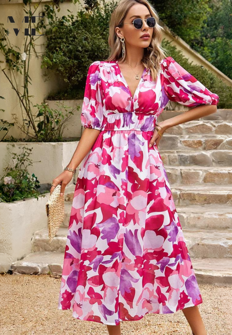 Pink - Woman wearing a multicolored abstract floral chiffon midi dress with a V-neckline, elbow-length puff sleeves, and a smocked waist, standing outdoors on stone steps.