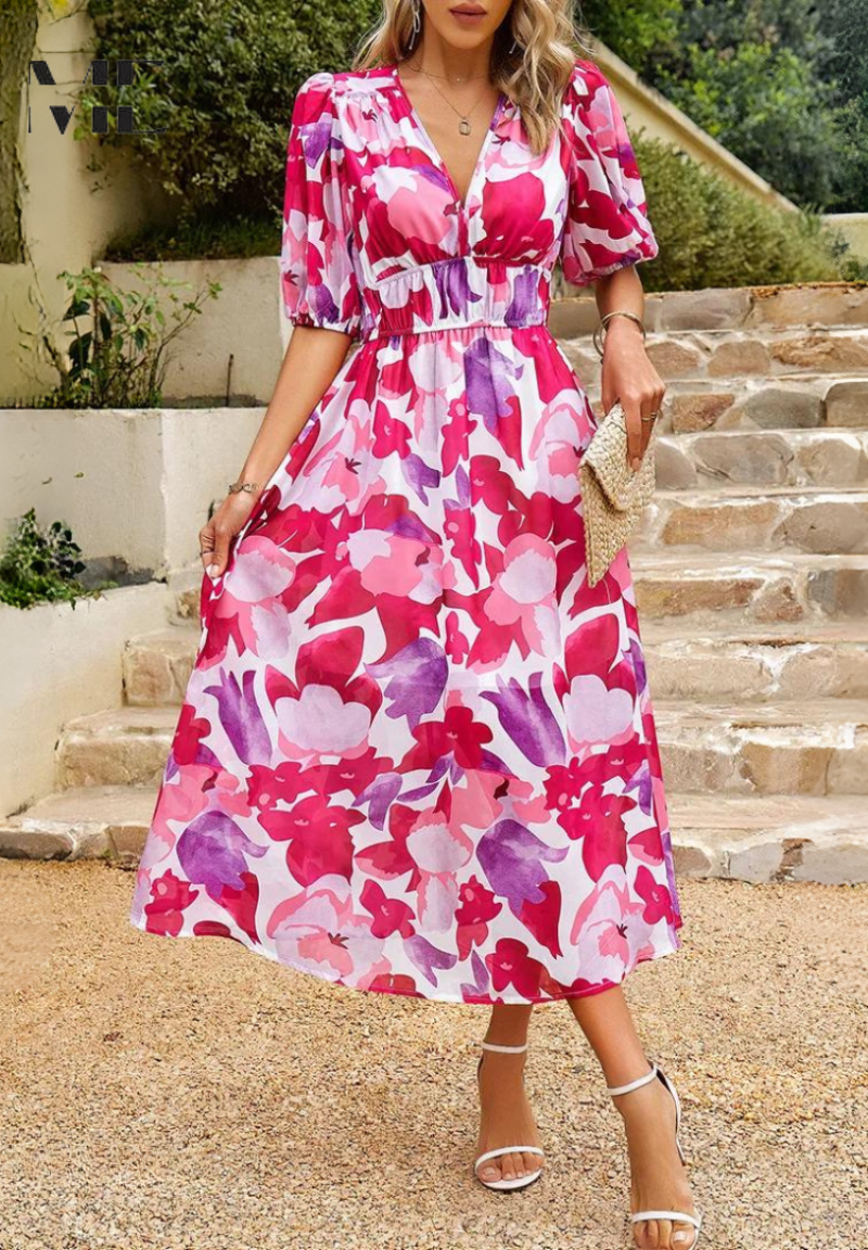 Pink - Woman wearing a multicolored abstract floral chiffon midi dress with a V-neckline, elbow-length puff sleeves, and a smocked waist, standing outdoors on stone steps.