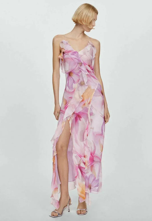 Floral pink - Model wearing a flowing chiffon maxi dress featuring a large-scale watercolor floral print, delicate spaghetti straps, cascading ruffles, and a high side slit.