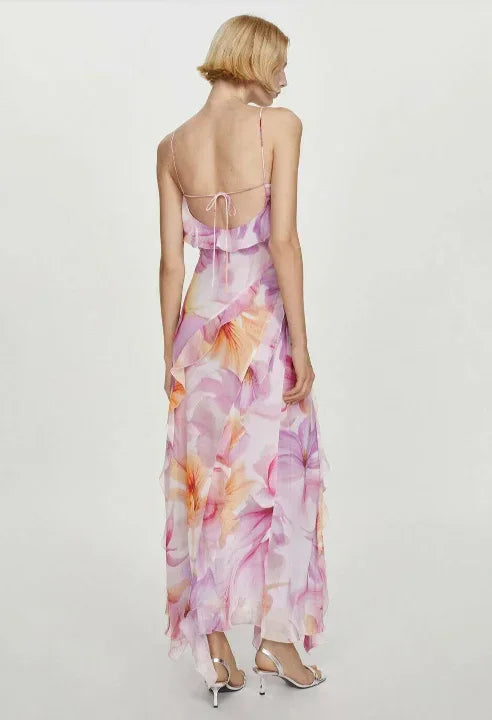 Floral pink - Model wearing a flowing chiffon maxi dress featuring a large-scale watercolor floral print, delicate spaghetti straps, cascading ruffles, and a high side slit.