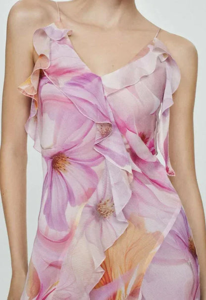 Floral pink - Model wearing a flowing chiffon maxi dress featuring a large-scale watercolor floral print, delicate spaghetti straps, cascading ruffles, and a high side slit.