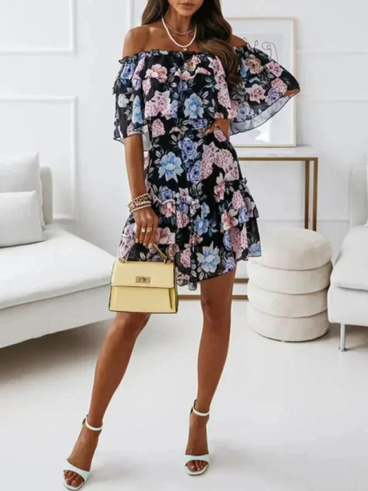 Black floral chiffon mini dress featuring an off-the-shoulder ruffled neckline and a tiered skirt.
