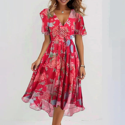 Pink - A woman wearing a dark green chiffon midi dress with a white ditsy floral print, featuring flutter sleeves, a surplice V-neckline, a self-tie waist, and a flowing curved hem.